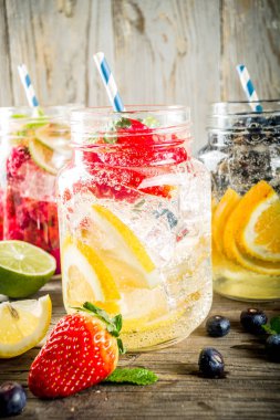 Çeşitli meyve ve meyve limonata içecekler, ferahlık infüzyon seçimi, su taze çilek, limon, limon, portakal, yaban mersini, mason kavanoz ahşap arka plan kopya alanı