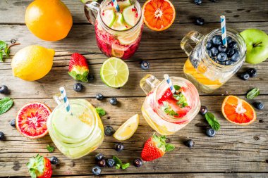 Çeşitli meyve ve meyve limonata içecekler, ferahlık infüzyon seçimi, su taze çilek, limon, limon, portakal, yaban mersini, mason kavanoz ahşap arka plan kopya alanı
