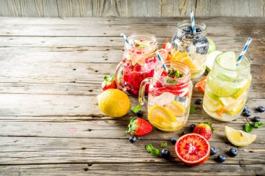 Çeşitli meyve ve meyve limonata içecekler, ferahlık infüzyon seçimi, su taze çilek, limon, limon, portakal, yaban mersini, mason kavanoz ahşap arka plan kopya alanı