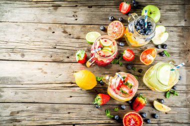 Çeşitli meyve ve meyve limonata içecekler, ferahlık infüzyon seçimi, su taze çilek, limon, limon, portakal, yaban mersini, mason kavanoz ahşap arka plan kopya alanı
