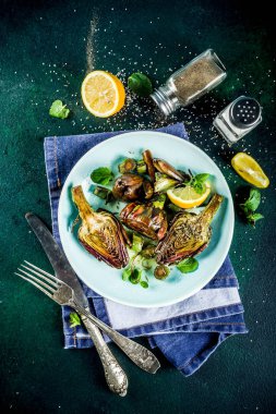Pişmiş pişmiş enginar, alla romana, zeytinyağı, limon, sarımsak, nane ve baharatlar ile enginar çiçek ızgara. Kopya alanı