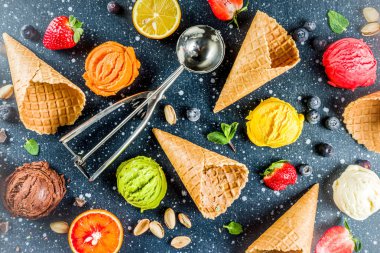 Renkli meyve ve berry, fındık, çikolata ve vanilyalı dondurma, taze meyve ve çilek, üstten görünüm kopya alanı koyu mavi arka plan ile gözleme Ice - cream koniler ile
