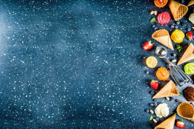 Renkli meyve ve berry, fındık, çikolata ve vanilyalı dondurma, taze meyve ve çilek, üstten görünüm kopya alanı koyu mavi arka plan ile gözleme Ice - cream koniler ile