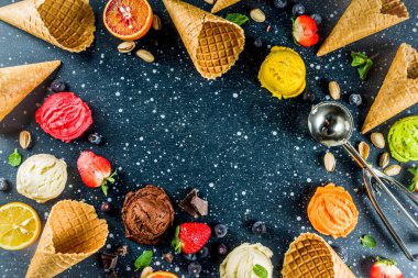 Renkli meyve ve berry, fındık, çikolata ve vanilyalı dondurma, taze meyve ve çilek, üstten görünüm kopya alanı koyu mavi arka plan ile gözleme Ice - cream koniler ile