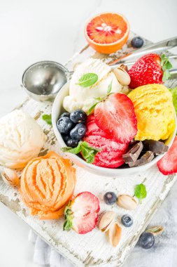 Renkli meyve ve berry, fındık, çikolata ve vanilyalı dondurma, taze meyve ve çilek, üstten görünüm Kopyala yer beyaz mermer arka plan ile gözleme Ice - cream koniler ile