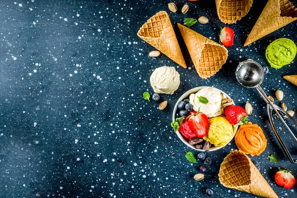 五颜六色的水果和浆果 巧克力和香草冰淇淋 与华夫饼冰淇淋锥 新鲜的水果和浆果 顶视图复制空间深蓝色背景 — 图库照片