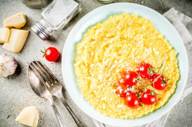 Sebzeli polenta. Mısır püresi taze kiraz domates ve parmesan peyniri ile arka plan kopya alanı gri taş beton