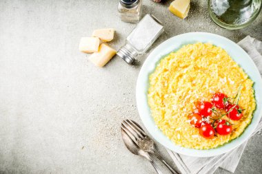 Sebzeli polenta. Mısır püresi taze kiraz domates ve parmesan peyniri ile arka plan kopya alanı gri taş beton
