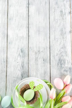Paskalya tatili sofra tavşan ve yumurta, renkli yumurta ve çikolata bunny tavşan, şenlikli şerit, ahşap arka plan üstten görünüm kopya alanı ile plakalar ile