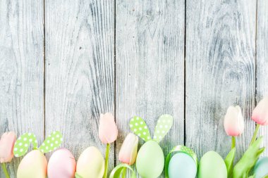 Paskalya tatili sofra tavşan ve yumurta, renkli yumurta ve çikolata bunny tavşan, şenlikli şerit, ahşap arka plan üstten görünüm kopya alanı ile plakalar ile