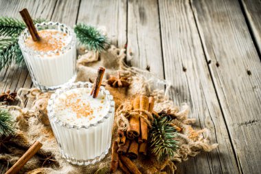 Klasik Noel içki yumurta likörü, Şili Cola de mono (maymun kuyruk) kokteyl ya da Porto Rikolu Coquito yumurta likörü, çam ağacı dalları kopya alanlarda eski ahşap zemin üzerine