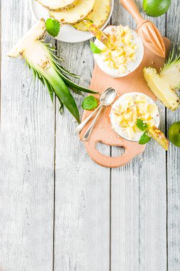 Ananas katmanlı kahvaltı parfe Yunan yoğurt, ev yapımı granola, ananas dilimleri, nane, ahşap arka plan,