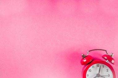 Parlak pembe masada küçük kırmızı çalar saat