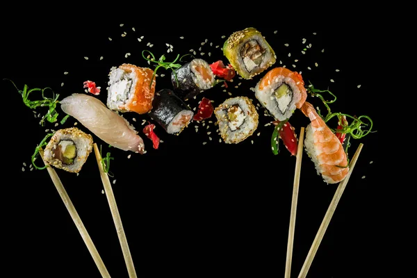Çeşitli uçan suşi siyah ayarlayın. Japon klasik suşi, suşi nigiri. rulo, soya sosu, zencefil, yemek çubukları.