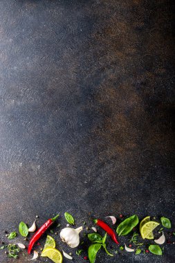Baharat, bitki ve sebze çeşitleri. Yemek yapmak için gerekli malzemeler. Yemek arkaplanı. Siyah taş masa, metin için uzayı kopyala. Üst görünüm.