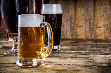 Ahşap bar arka planında farklı türde el yapımı bira. Çeşitli bira bardakları ve kupalar. Bira tatma konsepti