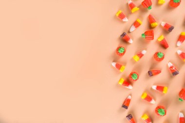 Mısır şekerlemeleri ve kabak şekerlemeleri şeftali rengi sonbahar arka plan düz fotokopi alanı uzanıyor. Geleneksel sonbahar Cadılar Bayramı ve Şükran Günü tatlıları