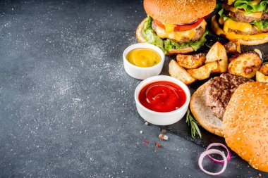 Lezzetli ev yapımı çizburger, sığır eti, domates, peynir, domates ve marul. Koyu gri arka planda, soslu. Üst görünüm kopyalama alanı