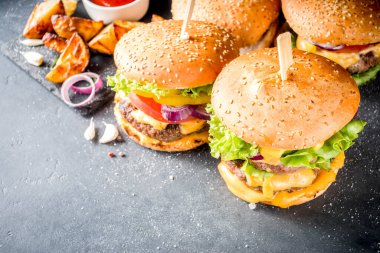 Lezzetli ev yapımı çizburger, sığır eti, domates, peynir, domates ve marul. Koyu gri arka planda, soslu. Üst görünüm kopyalama alanı