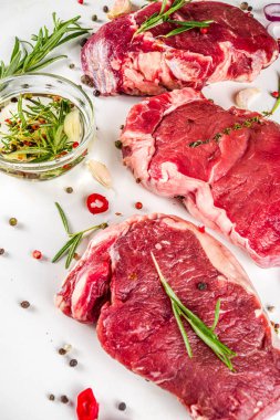 Çiğ et, biftek ve biberiye ve baharat, beyaz arka plan, üst görünüm kopyalama alanı.