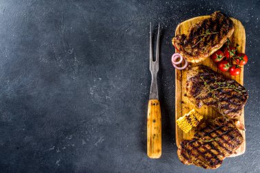 Et arka planı yapıyorum. Koyu gri masa arkasında taze ızgara et. Üst Manzara. Boşluğu kopyala