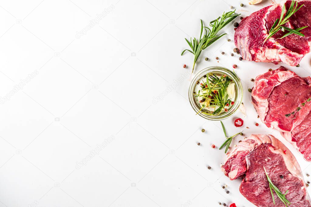 Raw meat, beef steak on cutting board with rosemary and spices, white background, top view copy space