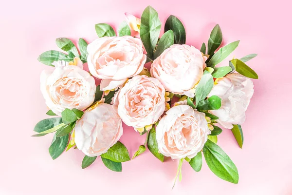 Floral peonies arrangement . Artificial tender white pinkish peony flower with leaves, flat composition on a light background. top view place for text