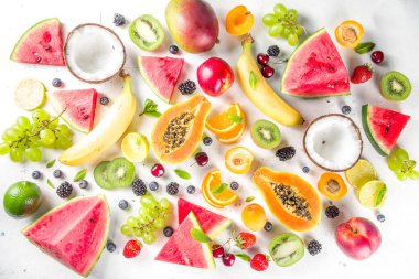  Farklı tropik taze meyve ve böğürtlen çeşitleri. Temiz yemek, sağlıklı yaşam tarzı, diyet ve vitamin konsepti. Üst görünüm düz beyaz masa arkaplanı