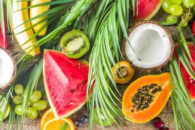 Farklı tropik taze meyve ve böğürtlen çeşitleri. Temiz yemek, sağlıklı yaşam tarzı, diyet ve vitamin konsepti. Üst görünüm düz tahta masa arkaplanı