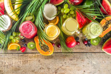 Farklı meyve suları ve meyve suları ile tropik taze meyve ve böğürtlenler. Temiz yemek, sağlıklı yaşam tarzı, diyet ve vitamin içecekleri konsepti. Üst görünüm düz beyaz masa arkaplanı 