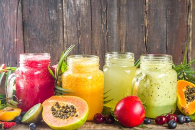 Farklı meyve suları ve meyve suları ile tropik taze meyve ve böğürtlenler. Temiz yemek, sağlıklı yaşam tarzı, diyet ve vitamin içecekleri konsepti. Üst görünüm düz beyaz masa arkaplanı 