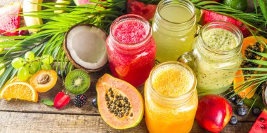 Farklı meyve suları ve meyve suları ile tropik taze meyve ve böğürtlenler. Temiz yemek, sağlıklı yaşam tarzı, diyet ve vitamin içecekleri konsepti. Üst görünüm düz beyaz masa arkaplanı 