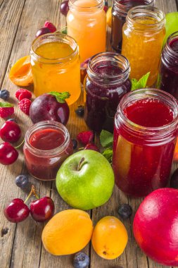 Böğürtlen ve meyve reçeli çeşitleri. Mevsimlik çeşitli yaz meyveleri, meyve reçeli, marmelat ve konfeksiyon setleri. Ahşap kırsal arkaplan kopyalama uzayı