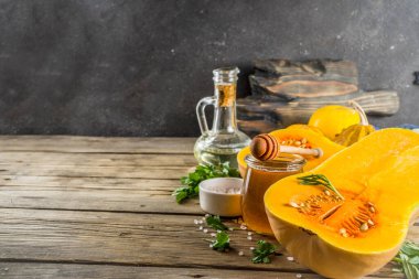 Çiğ kabak butternut kabak, zeytinyağı, baharat ve rustik eski ahşap arka plan üzerinde pişirmek için malzemeler le yarım. En iyi görünüm kopyalama alanı.