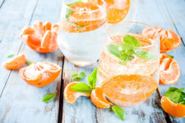 Yaz mandalina narenciye içecek, limonata veya mojito, taze mandalina, limon ve nane mavi ahşap masada,