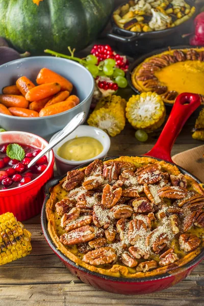 Thanksgiving family dinner setting concept. Traditional Thanksgiving day food  with turkey, green beans and mashed potatoes, stuffing, pumpkin, apple and pecan pies, rustic wooden table