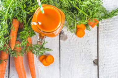Turuncu turuncu havuç püresi ya da beyaz ahşap arka planda taze havuçlu mason kavanozunda meyve suyu. Vejetaryen sebze püresi.