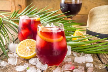 Tinto de Verano veya şarap de verano, İspanyol şarabı kokteyli. Acolik içecek sangria. Limon suyu ve dilimli soğuk buzlu alkol içeceği, yaz için tropikal dekor alanı olan ahşap arka plan.