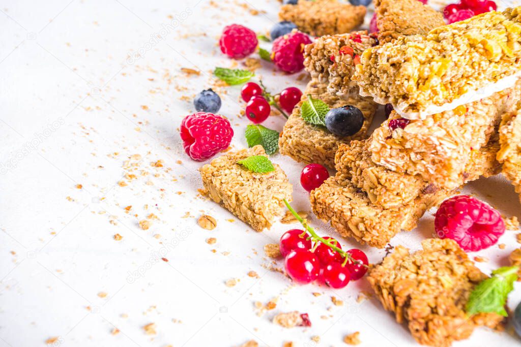 Healthy snack concept,  Cereal granola bars with fresh berries and nuts on white background copy space