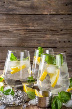 Limonata, taze fesleğen yaprağı, limon ve ezilmiş buz, sade ahşap arka plan kopyalama alanı.