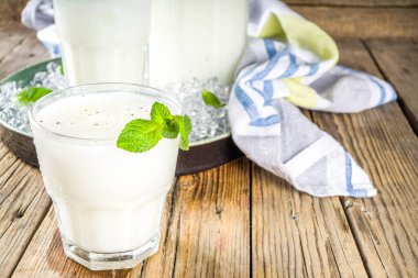 Soğuk Hint içeceği Lassi, buzlu hindistan cevizi Lassi, nane yaprağı, ahşap arka plan kopyalama alanı
