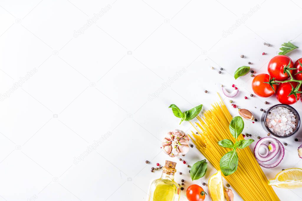 Italian food ingredients for  cooking Spaghetti Pasta. Raw spaghetti pasta with various ingredient - onion, tomatoes, garlic, basil, parsley, cheese, olive oil. On white table background, flatlay copy space