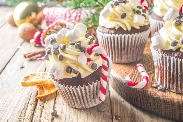 圣诞纸杯蛋糕圣诞节热巧克力蛋糕与薄荷糖手杖 巧克力滴和棉花糖 木制背景 圣诞装饰和冷杉树枝 甜蜜的圣诞烘焙 — 图库照片