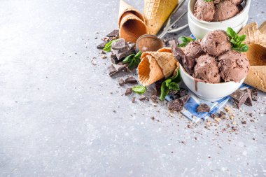 Ev yapımı çikolatalı dondurma, çikolata parçaları, talaş ve dondurma külahları. Beyaz gri taş masa üzerindeki küçük beyaz kaselerde fotokopi alanı