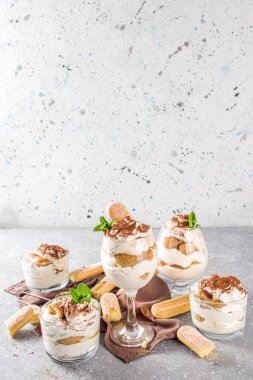 Geleneksel İtalyan tatlı tiramisusu. Çikolata tozu, gri taş taşı ya da beton arkaplan içeren ev yapımı tiramisu..