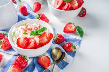 Yaz sabahı sütlü pirinç pudingi ya da çilekli pirinç lapası ve küçük bir kasede çilek şurubu, süt ve taze çilek fotokopi alanı.