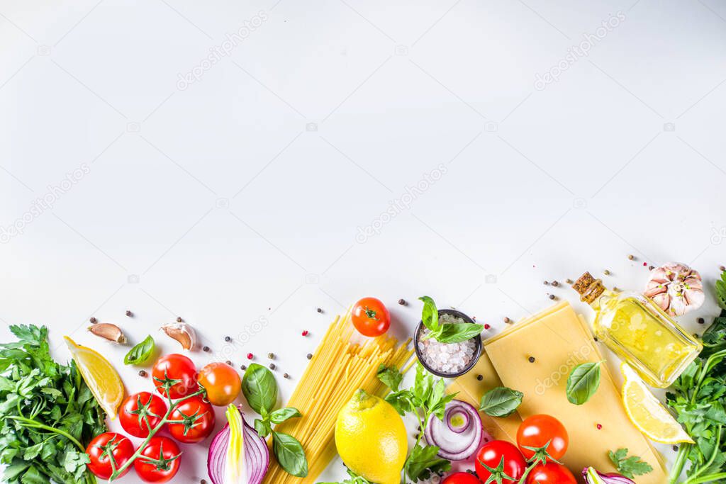 Italian food ingredients for  cooking Spaghetti Pasta. Raw spaghetti pasta with various ingredient - onion, tomatoes, garlic, basil, parsley, cheese, olive oil. On white table background, flatlay copy space