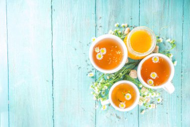 Papatya çayı ve bal doğal organik çay, mavi ahşap bir masada.