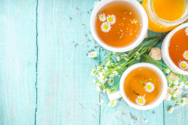 Papatya çayı ve bal doğal organik çay, mavi ahşap bir masada.