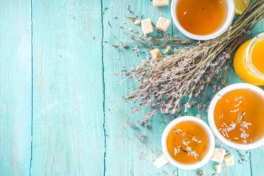 Aromatik lavantalı çay fincanı, lavanta demeti, bal ve limon, turkuaz ahşap arka plan fotokopi alanı